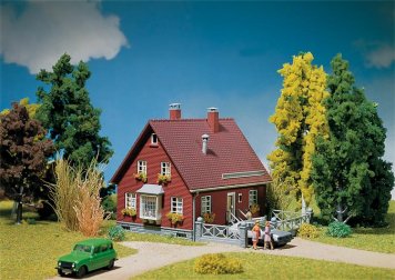 Stavebnice modelu venkovského domu s garáží, květinovými truhlíky a předzahrádkou.         Rozměr: 1