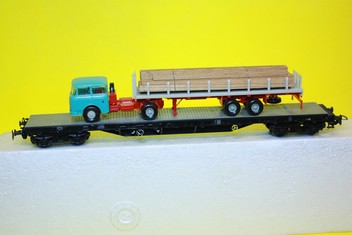 Plošinový vagon s nákladem auta se dřevem / Piko HO/